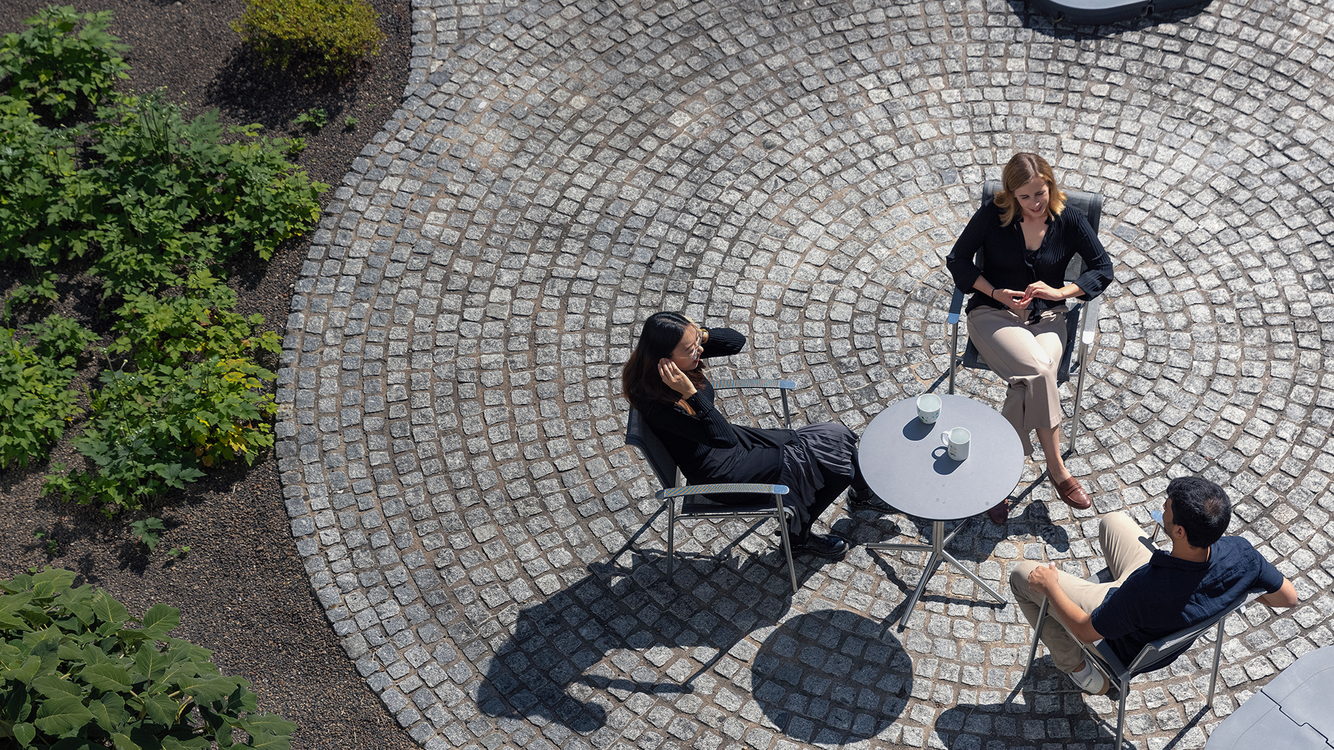 coworkers sitting outside around table with coffee